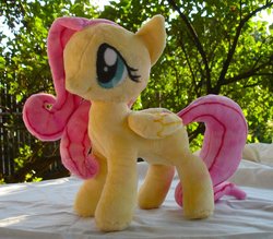 Size: 900x790 | Tagged: safe, artist:dolphinwing, fluttershy, pegasus, pony, g4, folded wings, irl, outdoors, photo, plushie, solo, wings