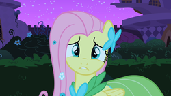 Size: 640x360 | Tagged: safe, screencap, fluttershy, pegasus, pony, g4, the best night ever, clothes, dress, female, folded wings, gala dress, lip bite, looking at you, mare, outdoors, royal gardens, solo, wings