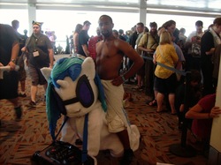 Size: 1280x959 | Tagged: safe, dj pon-3, vinyl scratch, human, pony, unicorn, g4, african american, convention, cosplay, crowd, duo focus, female, fursuit, glasses, i'm on a horse, indoors, irl, irl human, isaiah mustafa, looking at you, male, man, mare, meme, old spice, old spice guy, otakon, photo, pose, queue, riding, topless, towel
