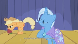 Size: 1600x900 | Tagged: safe, screencap, applejack, trixie, earth pony, pony, unicorn, boast busters, g4, season 1, apple, apple gag, cape, clothes, duo, duo female, eyes closed, female, food, gag, mare, rope, stage, tied up, trixie's cape, youtube caption