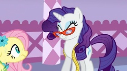 Size: 880x496 | Tagged: safe, screencap, fluttershy, rarity, pegasus, pony, unicorn, g4, season 1, suited for success, duo, eyes closed, glasses, measuring tape, messy mane, rarity's glasses, scrunchy face, sweat