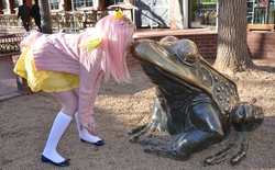 Size: 4072x2524 | Tagged: safe, artist:lochlan o'neil, fluttershy, frog, human, g4, brick wall, clothes, cosplay, craft, crouching, day, dress, female, hairpin, human female, irl, irl human, kissing, photo, railing, sculpture, skirt, solo, statue, sweater, sweatershy, tail, touching face, tree