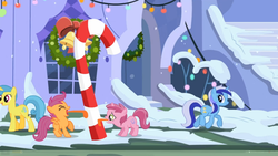 Size: 960x540 | Tagged: safe, screencap, lemon hearts, minuette, ruby pinch, scootaloo, pegasus, pony, unicorn, g4, hearth's warming eve (episode), 8 foot candy cane, candy cane, female, filly, hearth's warming eve, licking, mare, stuck, tongue out, tongue stuck to pole