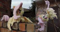 Size: 1661x881 | Tagged: safe, artist:meggchan, fluttershy, bat pony, pony, bats!, g4, flutterbat, irl, lying down, outdoors, photo, plushie, prone, race swap, that was fast