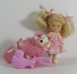 Size: 600x576 | Tagged: safe, photographer:breyer600, baby sundance, molly williams, earth pony, human, pony, g1, baby, baby pony, baby sundawwnce, beddy bye eye baby pony, beddy bye eyes, bow, bridle, clothes, comb, cute, dress, female, filly, irl, mollybetes, photo, tack, tail, tail bow, toy