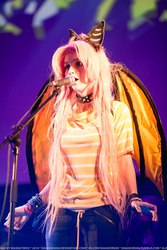 Size: 683x1024 | Tagged: artist needed, safe, fluttershy, human, g4, 2014, collar, cosplay, flutterbat, irl, irl human, microphone, photo, rubronycon, solo, stage