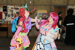 Size: 2048x1366 | Tagged: safe, artist:tsukino-con, madame leflour, pinkie pie, human, g4, 2013, backpack, clothes, convention, cosplay, duality, fight, fingerless gloves, gloves, hat, irl, irl human, party hat, party horn, photo, pinkamena diane pie, rubber duck, tsukino-con