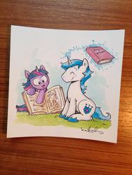 Size: 1024x1365 | Tagged: safe, artist:katie cook, idw, shining armor, twilight sparkle, g4, book, comic, cute, filly, grass, magic, photo, traditional art, younger
