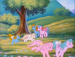 Size: 718x540 | Tagged: safe, screencap, baby half note, baby lofty, baby ribbon, baby tiddley-winks, buttons (g1), ribbon (g1), earth pony, pegasus, pony, unicorn, g1, little piece of magic, my little pony 'n friends, baby hawwlf note, baby loftybetes, baby ribbondorable, baby tiddlybetes, bow, cute, excited, female, filly, flower, g1 buttonbetes, hill, laughing, mare, meadow, playing, ribbondorable, running, tail, tail bow, tree