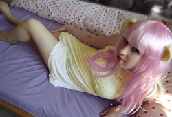 Size: 1024x696 | Tagged: safe, artist:amphyrainbows, fluttershy, human, g4, barefoot, bed, clothes, cosplay, dress, feet, irl, irl human, lipstick, looking at you, on back, photo, smiling, solo