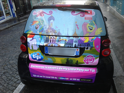 Size: 988x744 | Tagged: safe, fluttershy, rainbow dash, a canterlot wedding, g4, season 2, advertisement, canterlot castle, car, irl, itasha, massage, paris, photo, smart car, smart fortwo, tiji