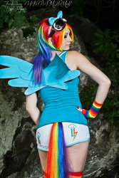 Size: 570x855 | Tagged: safe, artist:nikkinevermore, rainbow dash, human, g4, back, clothes, cosplay, fingerless gloves, gloves, irl, irl human, merchandise, photo, solo, tail