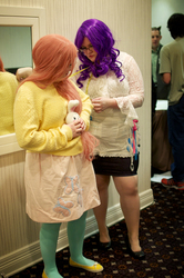 Size: 1275x1920 | Tagged: safe, artist:chubcakes, fluttershy, rarity, human, g4, brony fan fair, brony fan fair 2012, clothes, convention, cosplay, glasses, irl, irl human, measuring tape, photo, plushie, sweater, sweatershy