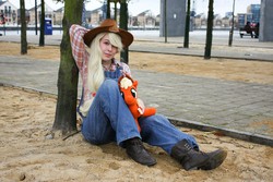 Size: 1000x667 | Tagged: safe, artist:nwahsinparis, applejack, human, g4, 2012, convention, cosplay, irl, irl human, london mcm expo, overalls, photo, plushie, sitting, solo