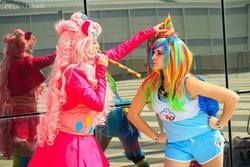 Size: 740x493 | Tagged: safe, artist:kikyo kompa, artist:miyako, pinkie pie, rainbow dash, human, g4, cosplay, dressing, hat, irl, irl human, party hat, party horn, photo, romics, unamused