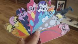 Size: 600x337 | Tagged: safe, artist:ladynanaki, applejack, derpy hooves, fluttershy, pinkie pie, rainbow dash, rarity, twilight sparkle, oc, oc:fluffle puff, pegasus, pony, g4, bookmark, female, mane six, mare