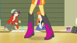 Size: 1280x720 | Tagged: safe, screencap, golden hazel, normal norman, sunset shimmer, equestria girls, g4, my little pony equestria girls: rainbow rocks, background human, boots, high heel boots, paintbrush, shoes, unamused