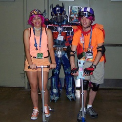 Size: 960x960 | Tagged: safe, scootaloo, human, bronycon, g4, cosplay, irl, irl human, optimus prime, photo, photobomb, transformers