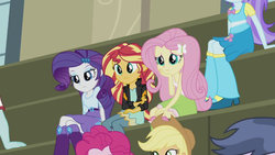 Size: 1280x720 | Tagged: safe, screencap, applejack, aqua blossom, curly winds, fluttershy, micro chips, pinkie pie, rarity, some blue guy, sunset shimmer, equestria girls, g4, my little pony equestria girls: friendship games, background human, boots, chs rally song, clothes, cowboy hat, hat, high heel boots, jewelry, sitting, skirt