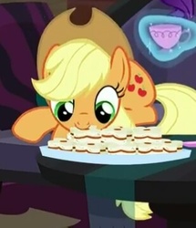 Size: 309x360 | Tagged: safe, screencap, applejack, earth pony, pony, g4, made in manehattan, biscuits, cup, cute, eating, female, jackabetes, magic, mare, mouth hold, nom, prone, smiling, solo, teacup