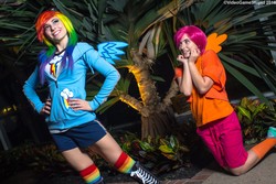 Size: 5184x3456 | Tagged: safe, artist:cosplayhazard, artist:meotashie, artist:videogamestupid, rainbow dash, scootaloo, human, g4, absurd resolution, admiration, breasts, busty rainbow dash, clothes, cosplay, costume, cutie mark on clothes, duo, fake wings, female, goggles, hand on hip, hoodie, irl, irl human, katsucon, katsucon 2016, kneeling, multicolored hair, photo, pose, rainbow hair