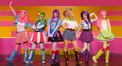 Size: 1019x555 | Tagged: safe, applejack, fluttershy, pinkie pie, rainbow dash, rarity, twilight sparkle, human, equestria girls, g4, my little pony & equestria girls el show en vivo, actress, boots, clothes, compression shorts, cosplay, costume, denim skirt, irl, irl human, live action, mane six, photo, pleated skirt, shorts, skirt, theater