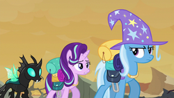 Size: 1280x720 | Tagged: safe, screencap, starlight glimmer, thorax, trixie, changeling, pony, unicorn, g4, to where and back again, looking back, raised hoof, spread wings, trixie's hat, walking