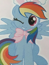 Size: 4032x3024 | Tagged: safe, screencap, rainbow dash, pegasus, pony, g4, bow, bunny ears, cropped, cute, dashabetes, female, looking at you, magazine, mare, merchandise, one eye closed, rainbow dash always dresses in style, sitting, smiling, wink