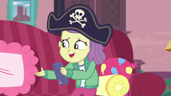 Size: 1920x1080 | Tagged: safe, screencap, lily pad (g4), equestria girls, g4, my little pony equestria girls: better together, pinkie sitting, child, clothes, couch, female, hat, indoors, open mouth, pants, phone, pillow, pirate hat, smartphone, solo, young