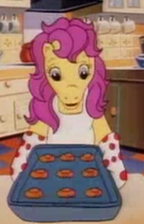 Size: 228x355 | Tagged: safe, screencap, bon bon (g1), earth pony, pony, g1, my little pony tales, apron, bipedal, bon bon's baking cookies girls, clothes, cookie, cropped, female, food, kitchen, oven mitts, solo
