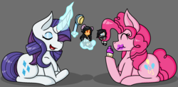Size: 1662x818 | Tagged: safe, artist:emmsi-world, pinkie pie, rarity, earth pony, pony, unicorn, g4, cupcake, curved horn, doll, duo, eating, eyes closed, female, food, glowing horn, gray background, hairbrush, horn, levitation, magic, mare, prehensile mane, prone, simple background, telekinesis, toy