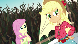 Size: 1280x720 | Tagged: safe, screencap, applejack, fluttershy, equestria girls, g4, my little pony equestria girls: legend of everfree, bare shoulders, boho, camp fashion show outfit, clothes, cowboy hat, cute, female, flower, freckles, hand on hip, hat, shorts, shyabetes, sleeveless, stetson