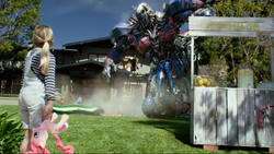 Size: 1136x640 | Tagged: safe, pinkie pie, pony, g4, clash of hasbro's titans, commercial, commercial reference, house, irl, lemonade stand, live action, optimus prime, photo, playground, plushie, pony cameo, pony reference, schick hydro, towel, toy, transformers, transformers the last knight, tree, upside down
