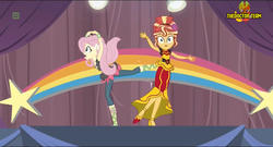 Size: 1352x730 | Tagged: safe, screencap, fluttershy, sunset shimmer, human, equestria girls, equestria girls specials, g4, my little pony equestria girls: dance magic, alternate hairstyle, clothes, female, flamenco dress, kicking, skirt, standing, standing on one leg, street ballet tutu, sunset shimmer flamenco dress, tutu