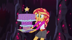 Size: 1100x618 | Tagged: safe, screencap, sunset shimmer, equestria girls, g4, my little pony equestria girls: legend of everfree, book, cake, camp everfree outfits, clothes, crystal gala, female, food, legend you were meant to be, shorts, solo