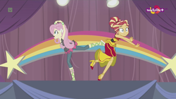 Size: 1136x638 | Tagged: safe, screencap, fluttershy, sunset shimmer, human, equestria girls, equestria girls specials, g4, my little pony equestria girls: dance magic, accident, alternate hairstyle, awkward moment, canterlot high, clothes, dancing, dress, duo, female, flamenco dress, high heels, rainbow, shoes, skirt, stars, street ballet tutu, sunset shimmer flamenco dress, teletoon, tutu