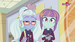 Size: 1136x638 | Tagged: safe, screencap, sugarcoat, sunny flare, equestria girls, equestria girls specials, g4, my little pony equestria girls: dance magic, bag, blunt, bowtie, canterlot mall, clothes, confused, crossed arms, crystal prep academy uniform, crystal prep shadowbolts, duo, female, flower, flower in hair, glasses, mall, school uniform, teletoon