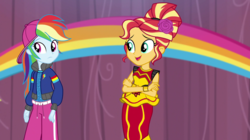Size: 1280x718 | Tagged: safe, screencap, rainbow dash, sunset shimmer, human, equestria girls, equestria girls specials, g4, my little pony equestria girls: dance magic, backwards ballcap, baseball cap, cap, clothes, crossed arms, dress, female, flamenco dress, flower, flower in hair, hat, hip hop, outfit, pants, rapper dash, stage, sunset shimmer flamenco dress