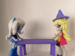 Size: 559x419 | Tagged: safe, artist:whatthehell!?, edit, derpy hooves, trixie, equestria girls, g4, animated, boots, clothes, doll, equestria girls minis, hat, irl, photo, shoes, skirt, table, toy