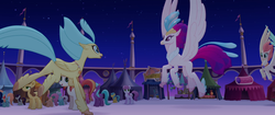 Size: 1920x804 | Tagged: safe, screencap, bell perin, blackberry scarf, chocolate apple, dawn sunrays, haven bay, princess skystar, queen novo, classical hippogriff, earth pony, hippogriff, pegasus, pony, g4, my little pony: the movie, background pony, canterlot, feathered fetlocks, female, flying, landing, male, mare, market, mother and daughter, rainbow (song), reunion, running, stallion, unnamed character, unnamed pony, wings