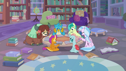 Size: 1280x720 | Tagged: safe, screencap, gallus, ocellus, sandbar, silverstream, smolder, yona, changedling, changeling, classical hippogriff, dragon, earth pony, griffon, hippogriff, pony, yak, g4, what lies beneath, book, bookshelf, bow, chair, cloven hooves, colored hooves, dragoness, female, globe, hair bow, library, male, monkey swings, sitting, student six, studying, table, tail, teenager