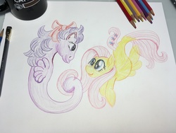 Size: 4032x3024 | Tagged: safe, artist:ciaran, derpibooru exclusive, fluttershy, sealight, sea pony, seapony (g4), g1, g4, 35th anniversary, coffee mug, drawing table, duo, female, holding, mare, mug, nanowrimo, pencil, pencil drawing, photo, seaponified, seapony fluttershy, simple background, smiling, species swap, traditional art, underwater, white background