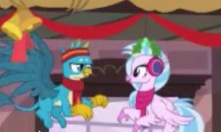 Size: 1435x859 | Tagged: safe, screencap, gallus, silverstream, classical hippogriff, griffon, hippogriff, g4, my little pony best gift ever, christmas decoration, clothes, cropped, duo, earmuffs, eye contact, female, flying, headband, looking at each other, low quality, male, mistleholly, needs more jpeg, ponyville, scarf, shipping fuel, train station, winter outfit
