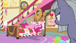 Size: 1280x720 | Tagged: safe, screencap, limestone pie, pinkie pie, earth pony, pony, g4, my little pony best gift ever, bed, bedroom, blue eyes, christmas decoration, duo, duo female, female, frown, gray coat, gray fur, gray pony, grey fur, grey pony, mare, open frown, open mouth, pie sisters, pink body, pink coat, pink fur, pink hair, pink mane, pink pony, pink tail, pinkie's bedroom, poofy hair, poofy mane, poofy tail, present, siblings, silver hair, silver mane, sisters, tail, yellow eyes