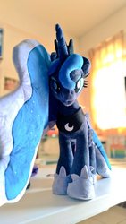 Size: 577x1024 | Tagged: safe, artist:nekokevin, princess luna, alicorn, pony, g4, :3, female, hoof shoes, irl, looking at you, mare, peytral, photo, plushie, regalia, smiling, solo, table
