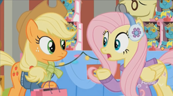 Size: 1350x752 | Tagged: safe, screencap, applejack, flim, fluttershy, holly the hearths warmer doll, g4, my little pony best gift ever, clothes, discovery family logo, earmuffs, glasses, shopping bag, sweater, table, winter outfit