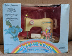 Size: 1017x786 | Tagged: safe, firefly, medley, pegasus, pony, g1, box, female, irl, mare, merchandise, my little pony logo, open mouth, photo, rainbow, sewing machine, spread wings, standing, vintage, wings