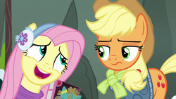 Size: 1280x720 | Tagged: safe, screencap, applejack, fluttershy, holly the hearths warmer doll, pony, g4, my little pony best gift ever, applejack is not amused, clothes, cute, earmuffs, unamused, winter outfit