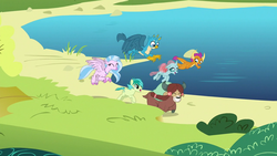 Size: 1280x720 | Tagged: safe, screencap, gallus, ocellus, sandbar, silverstream, smolder, yona, changedling, changeling, classical hippogriff, dragon, earth pony, griffon, hippogriff, pony, yak, g4, school daze, beach, bow, cloven hooves, colored hooves, dragoness, female, flying, hair bow, jewelry, male, monkey swings, necklace, student six, teenager, wings