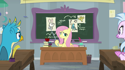 Size: 1280x720 | Tagged: safe, screencap, fluttershy, gallus, silverstream, classical hippogriff, griffon, hippogriff, pegasus, pony, g4, school daze, animal, apple, classroom, desk, drawing, female, food, male, mare, pointer, teacher, teaching